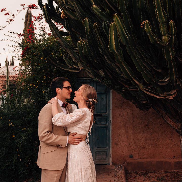 Bride in modern bridal separates walking with the groom in three piece cream suit 