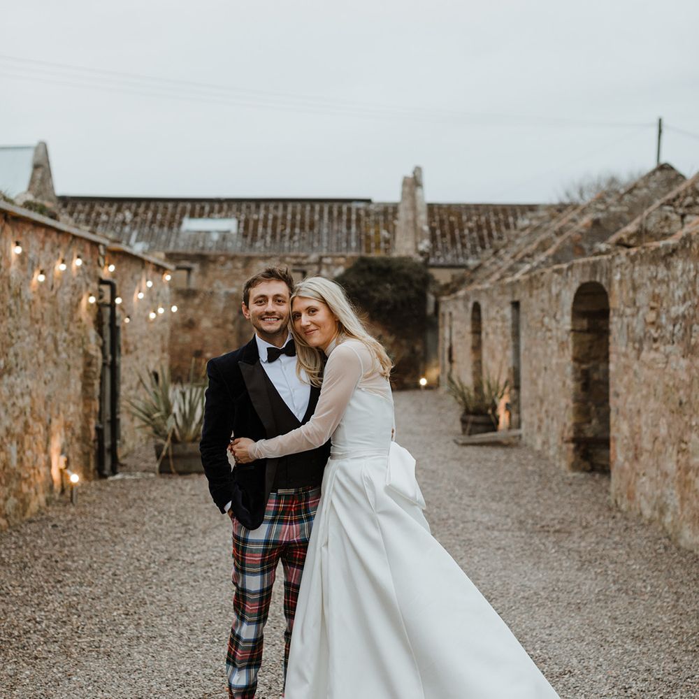 The Cowshed Crail wedding venue with the bride and groom posing together at the venue 