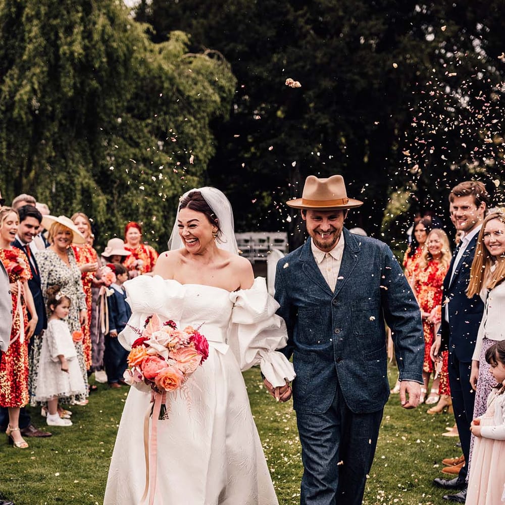 The bride and groom exit their wedding ceremony to confetti 