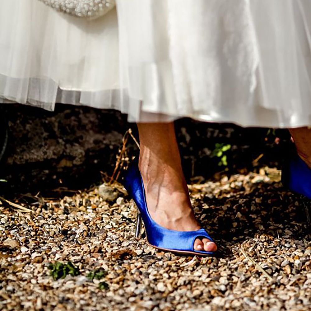 Bride wearing royal blue wedding shoes with puffy white wedding dress by Richard Jones Photography