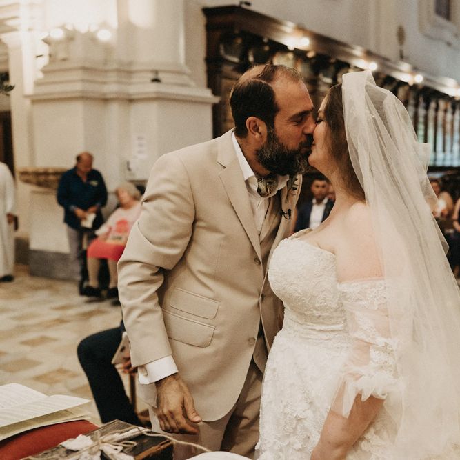 Bride and groom kiss at their Tuscany church wedding