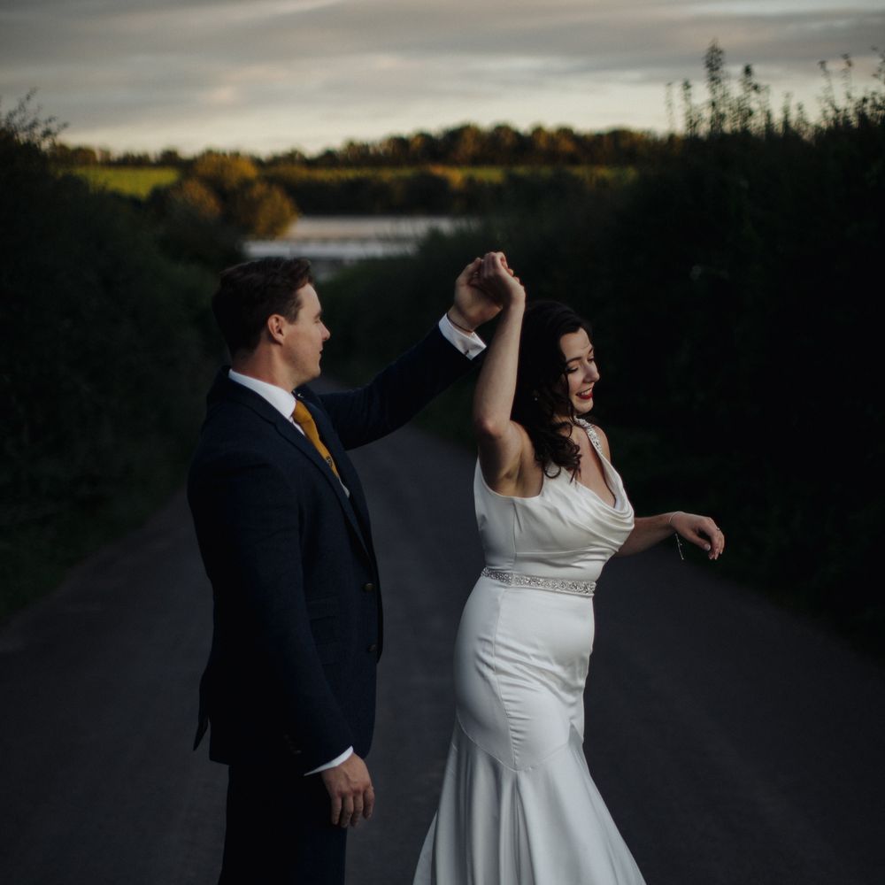 Groom twirls bride outside 