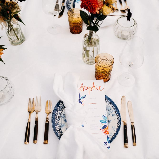Place setting with blue and white china, yellow glassware and black cutlery 