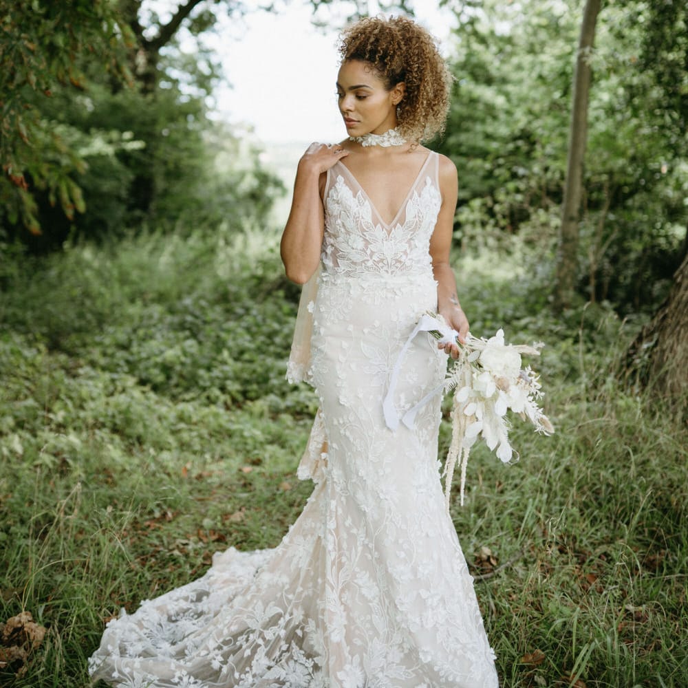Boho bride in the woods at Berwick Lodge wearing floral lace embroidered wedding dress with plunge neckline and lace edged bridal cape