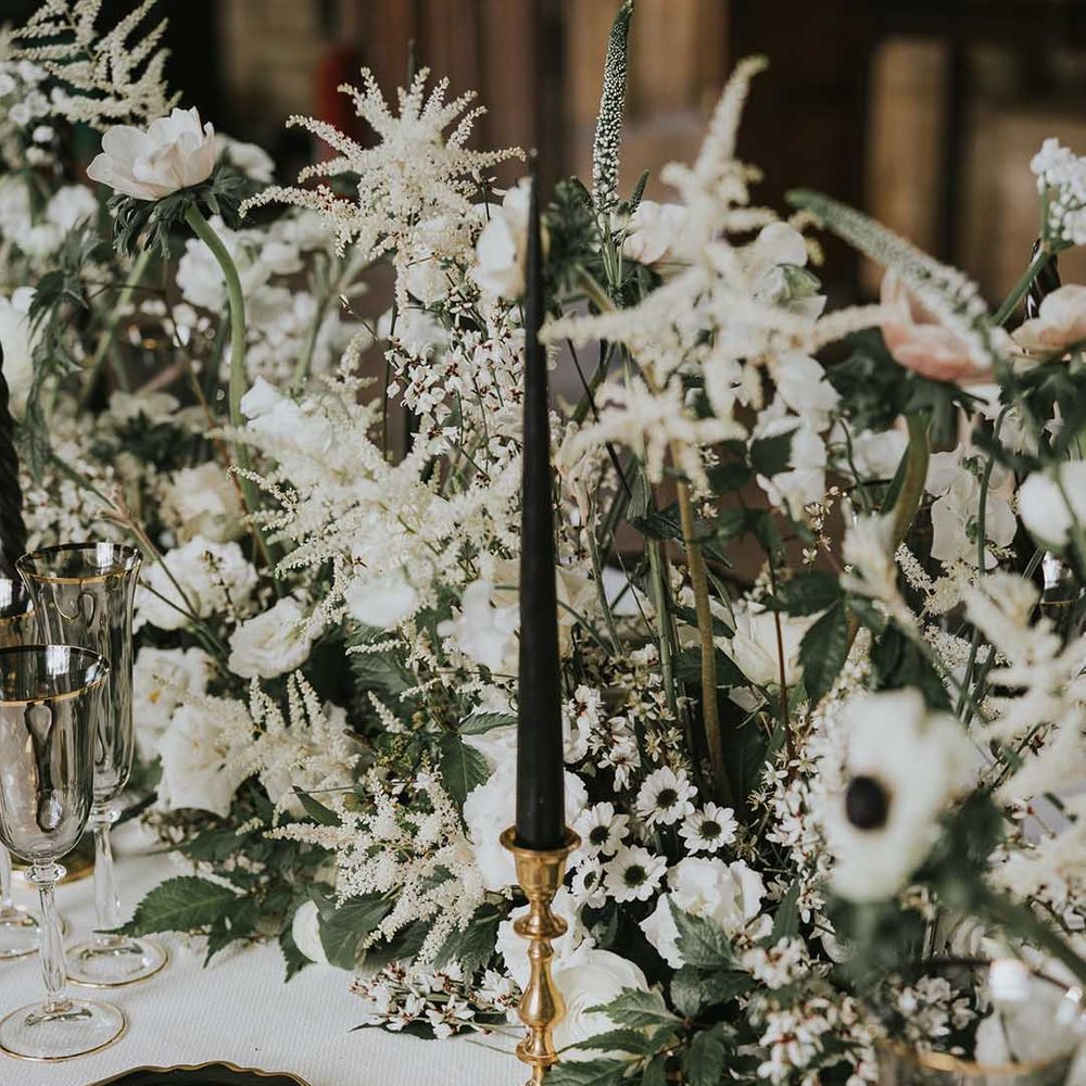 Black and white table wear and wedding flowers with gold accents 
