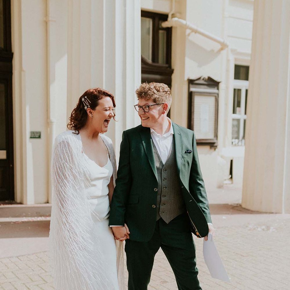 Bride & groom look lovingly at one another whilst smiling after wedding ceremony