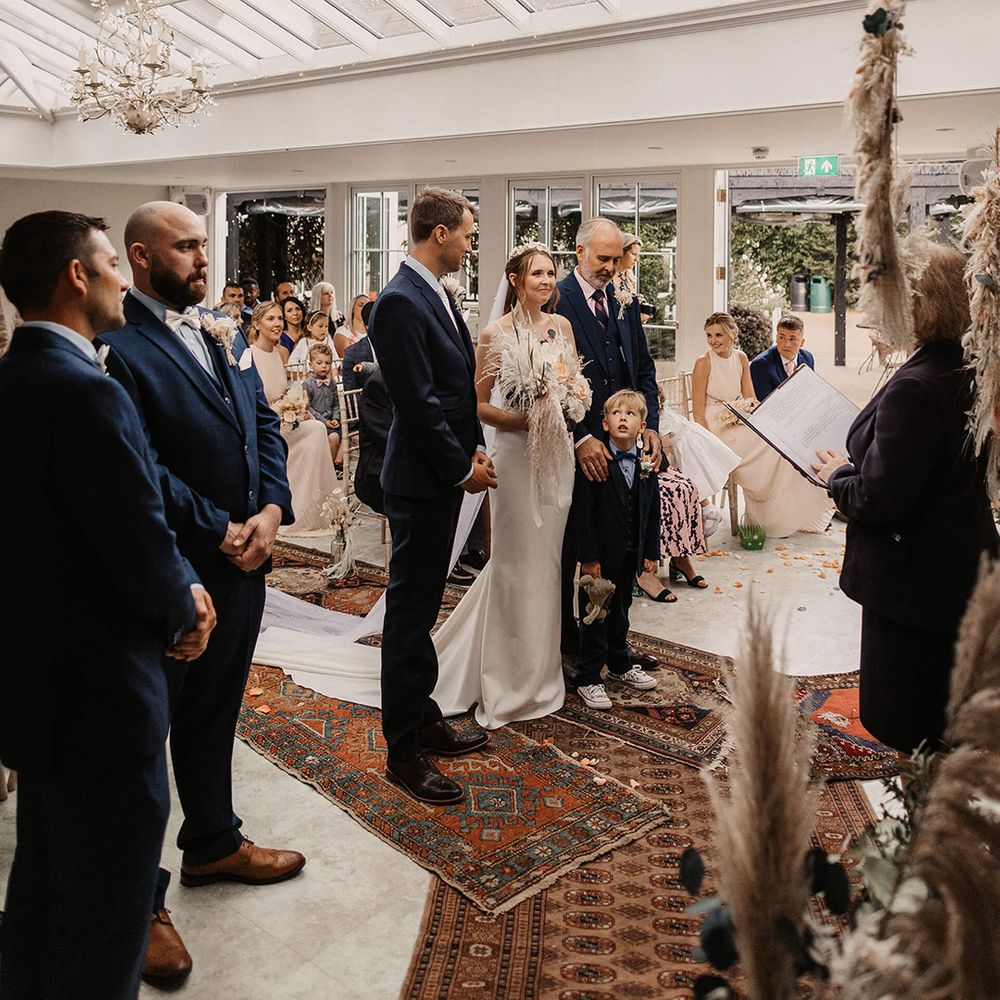 Bride & groom stand at the altar with their son and daughter on their wedding day