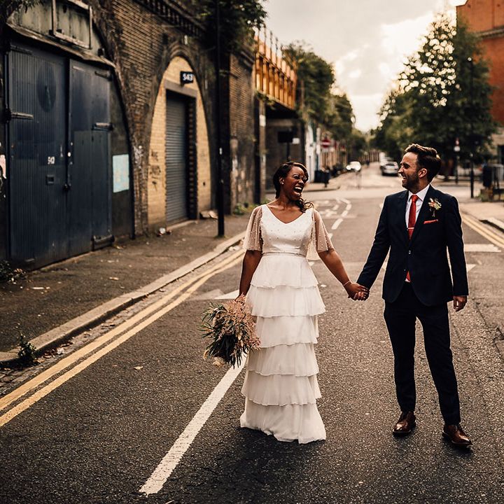 golden hour bride and groom portrait in London with Black bride in a layered tulle wedding dress and groom in a navy blue suit 