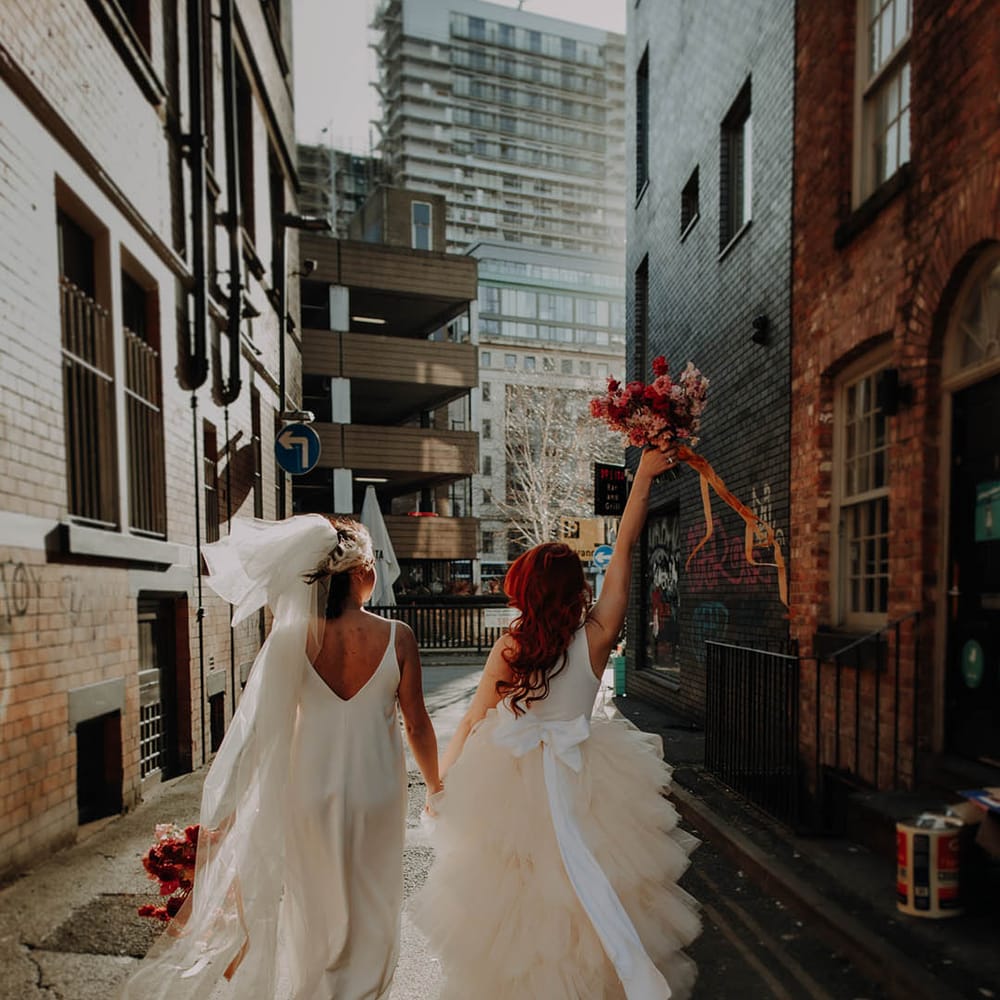 Manchester elopement with two brides in a layererd tulle wedding dress with bow and satin slip wedding dress long bow veil 