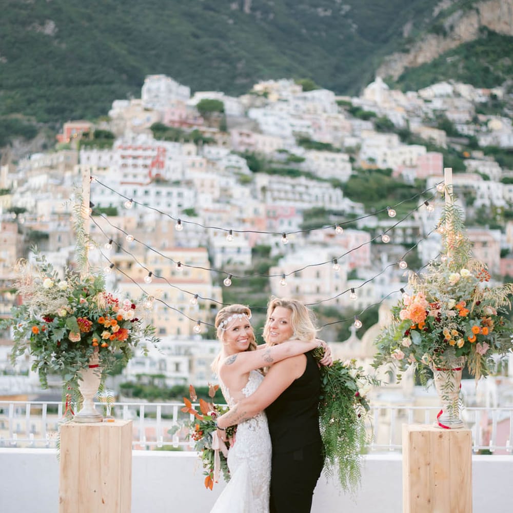 Couple hugging and laughing at the altar of their outdoor Italian wedding ceremony 