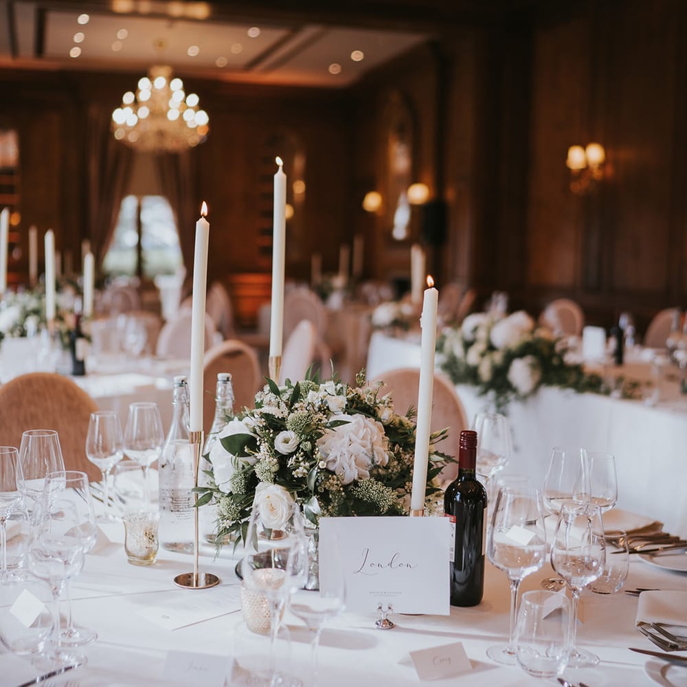 Circular wedding tables with white table cloths for classic wedding with white flower centrepieces 