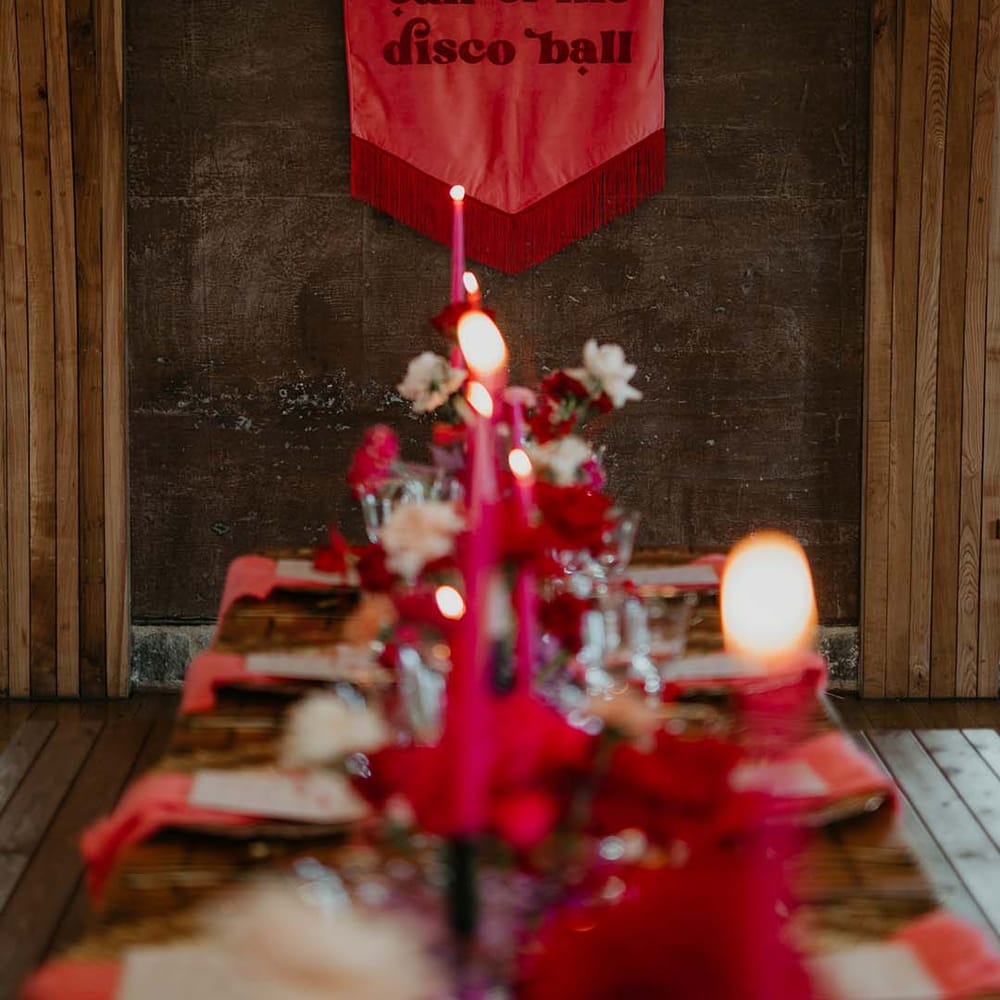 "Follow the call of the disco ball" embroidered viva magenta fabric wedding banner with a deep red fringe by disco themed hot pink and magenta wedding tablescape 