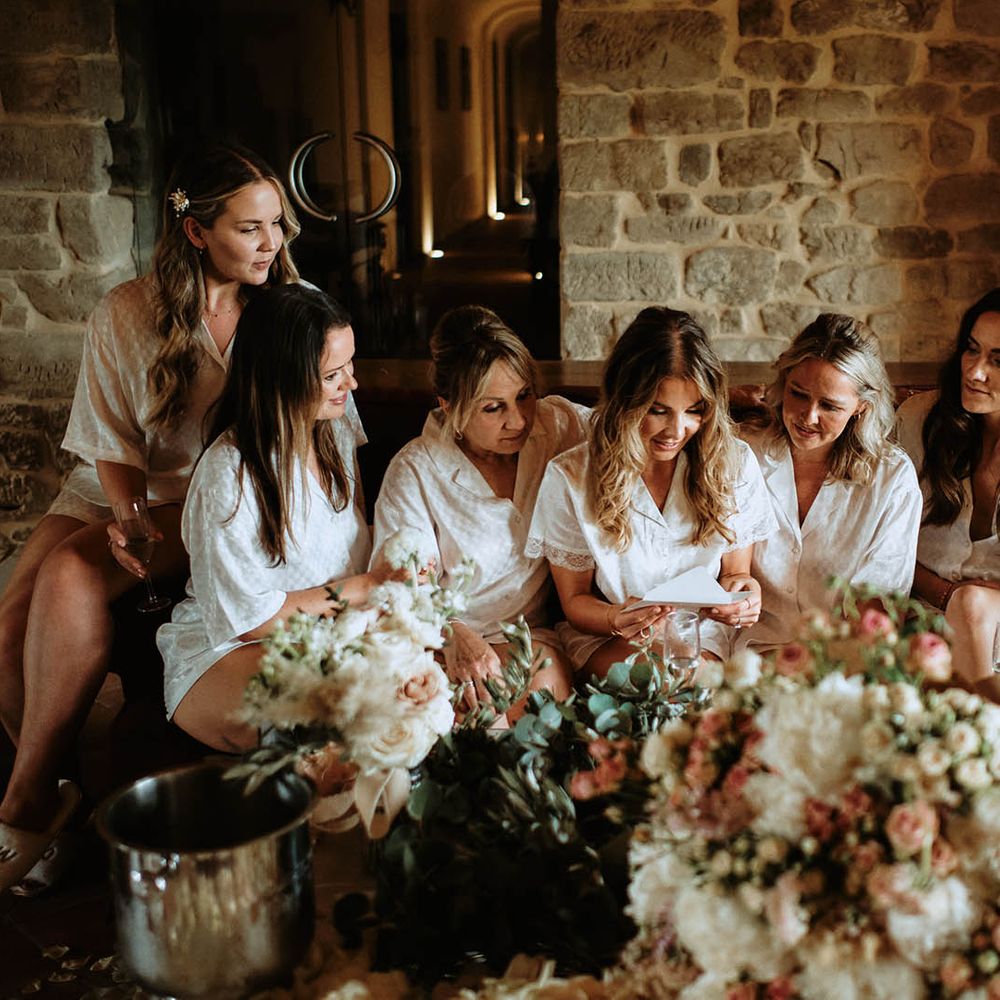 Bridal party and Bride wearing bridal pyjamas whilst reading a letter at destination wedding