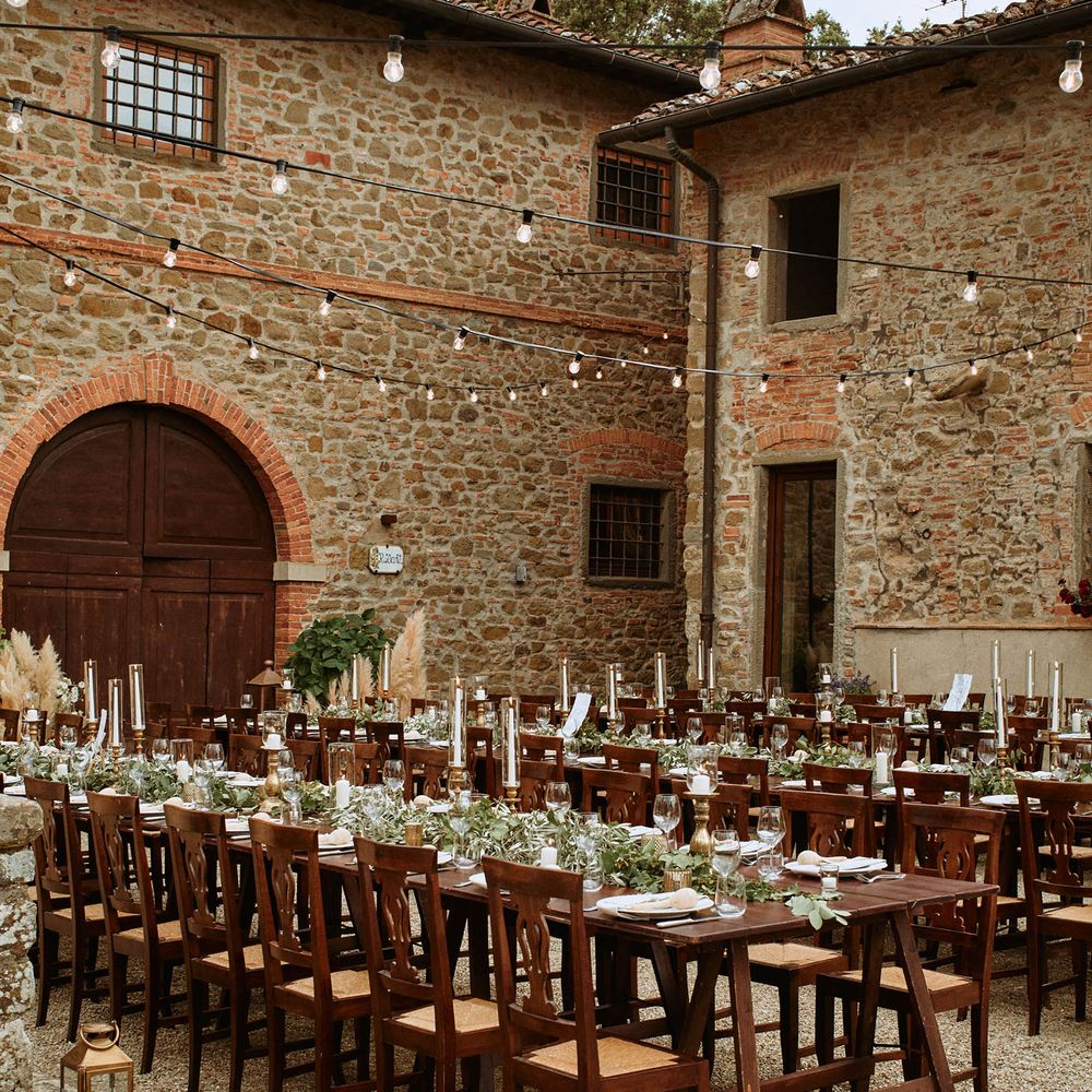 Ecalyptus tablescapes under festoon lighting at oudoor wedding in Italy