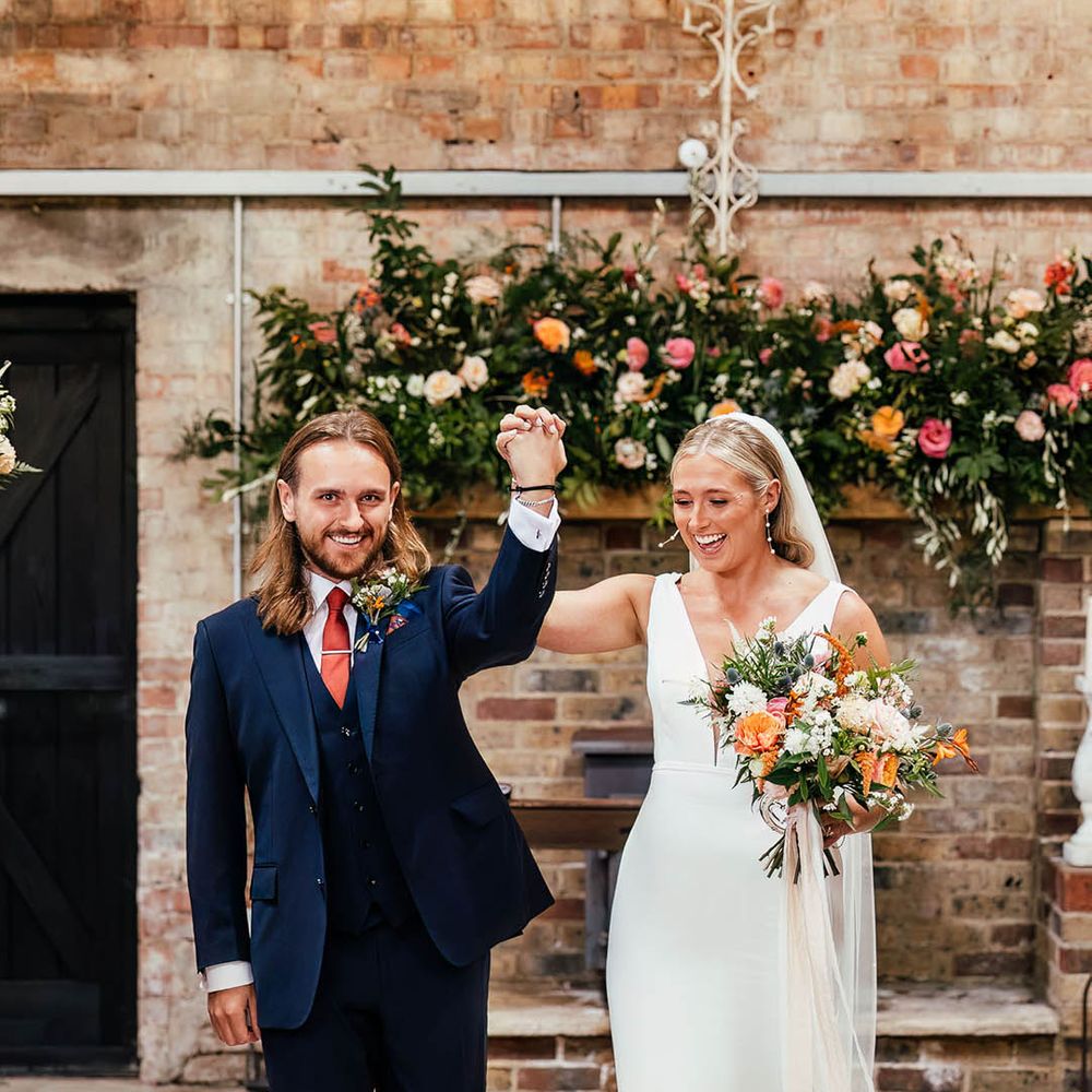The bride and groom walk back down the aisle as a married couple after their ceremony at Botley Hill Barn wedding venue 