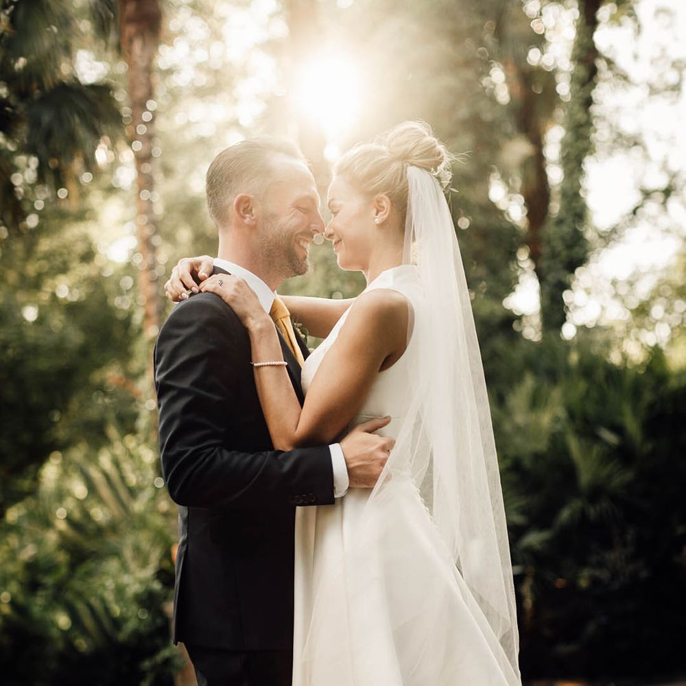 Classic country house wedding with bride in plunging neckline wedding dress with groom during golden hour 