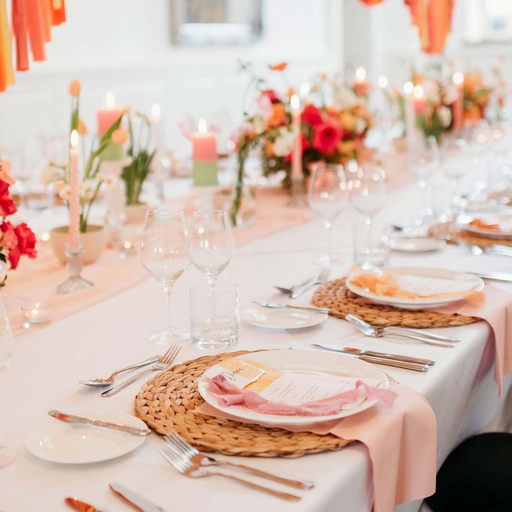 Merriscourt wedding reception room with wedding tablescape with white wedding tablecloth, burlap place mats, tapered candles, pink and orange wedding stationery, and floral wedding table centrepieces with pink and orange garden roses, orange floribunda, yellow ranunculus flowers, foliage and Iceland poppies 