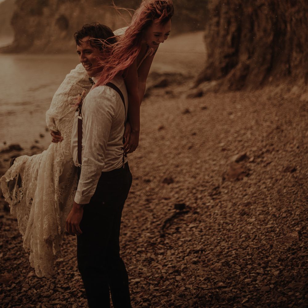 Groom lifting his bride over his shoulder