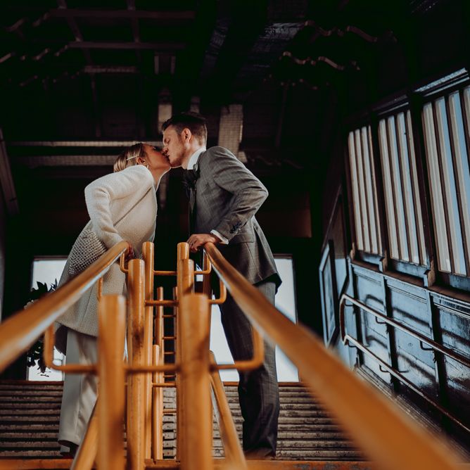 Bride and groom kissing at the tram station 
