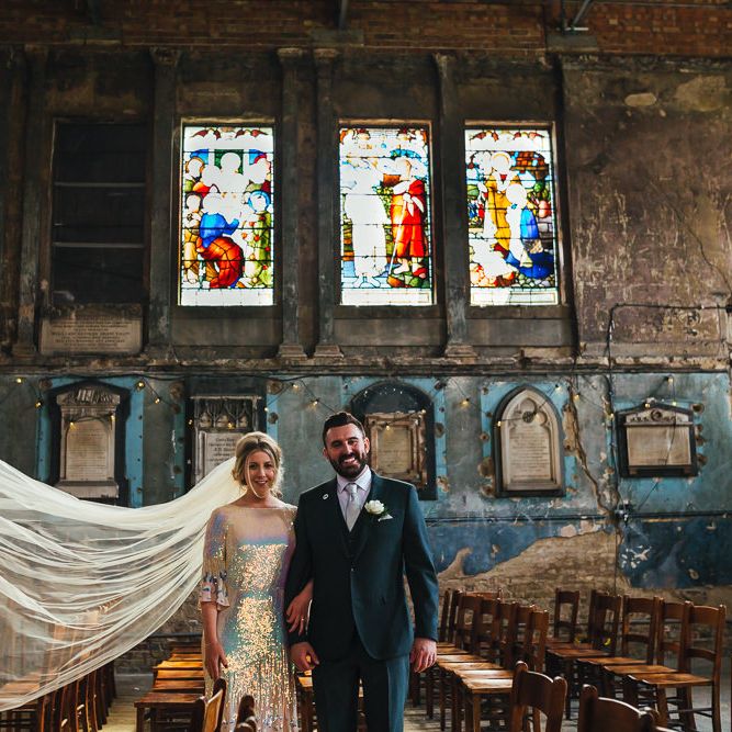 Bride & groom stand together and brides veil blows in the wind at The Asylum