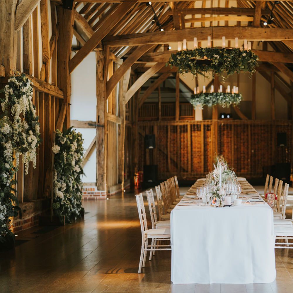 Micklefield Hall with large white table in a rustic setting surrounded by white florals
