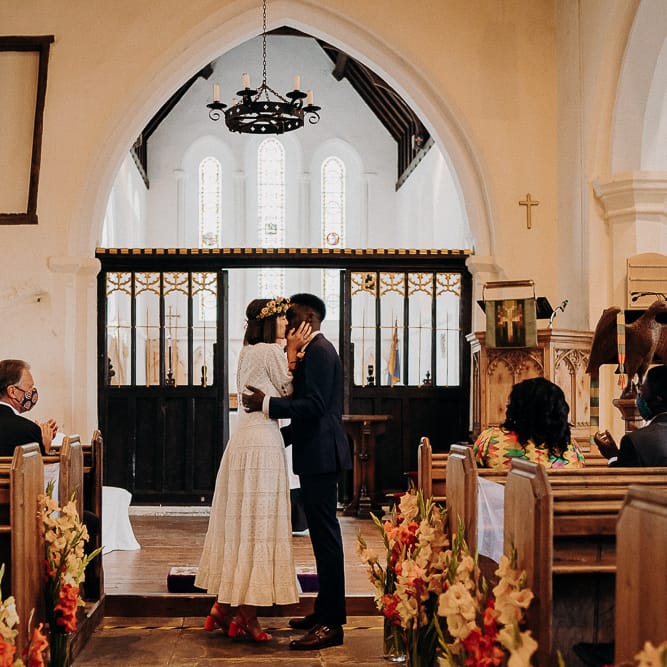 Church wedding ceremony with colourful gladiola pew end flowers 
