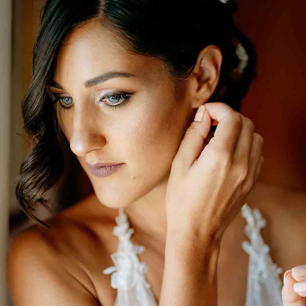 Bride with smokey eye makeup during preparations for romantic Italian wedding