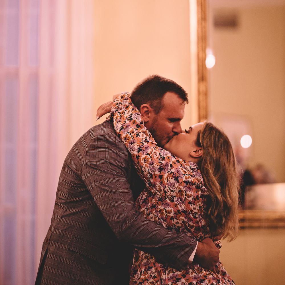 Bride wraps her arms around groom as they kiss on wedding day