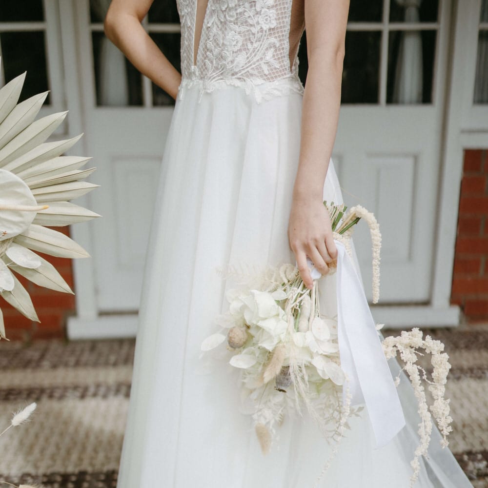 Bride holding an all white bouquet with a mix of dried and fresh flowers