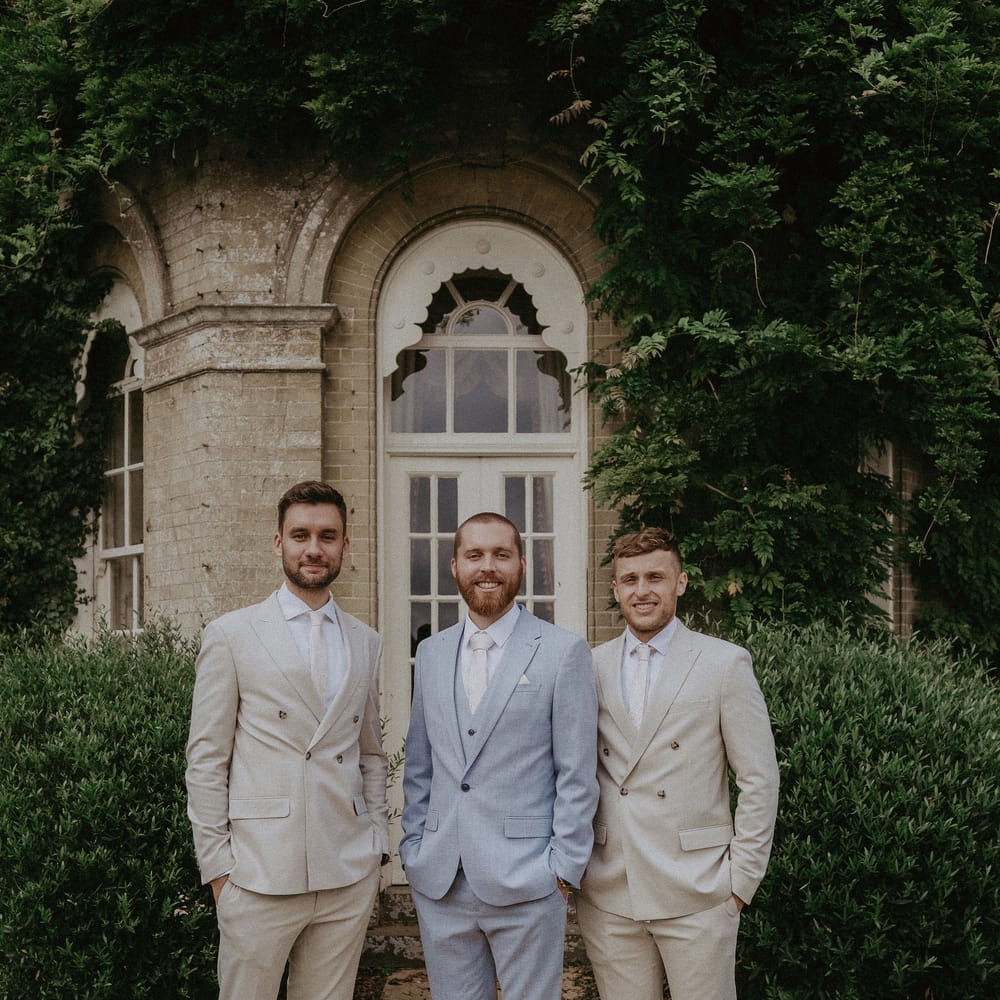 Groom in pale blue suit with groomsmen in cream wedding suits