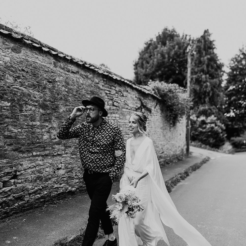 Bride & groom walk together through the streets on their wedding day