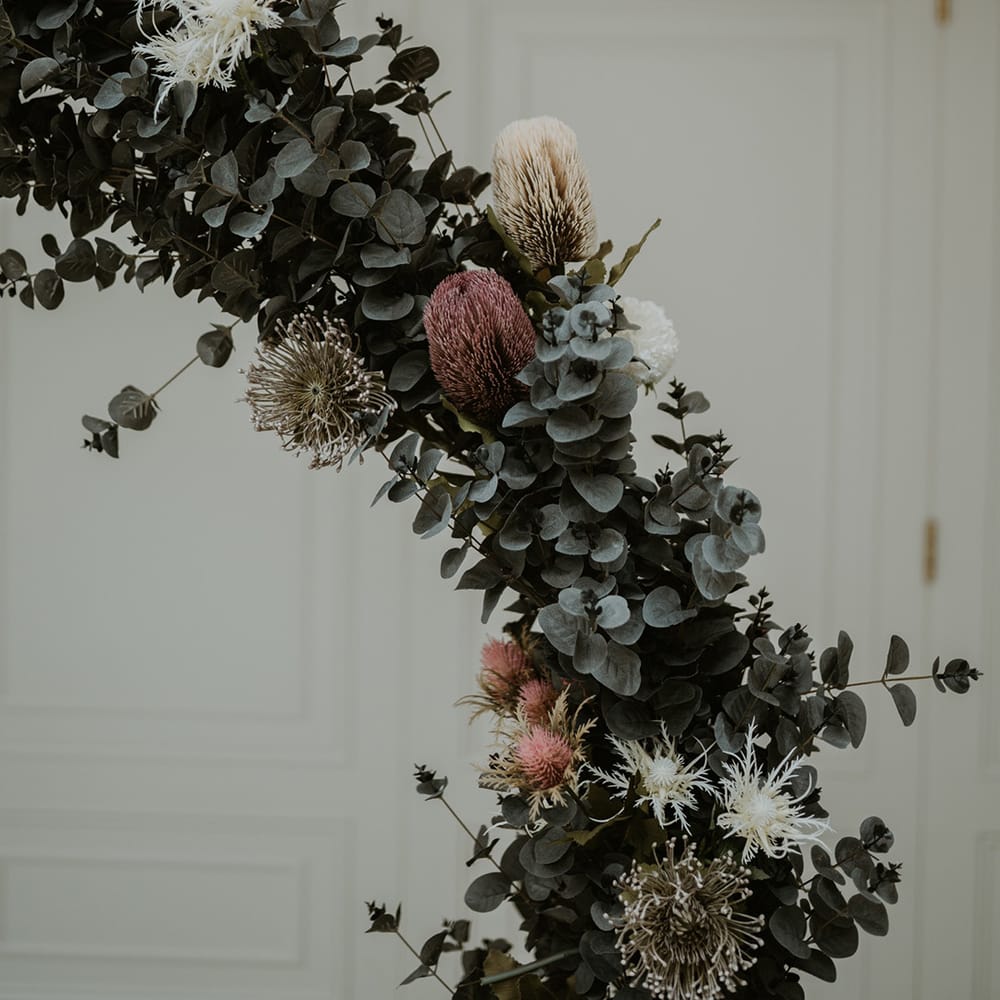 Floral archway complete with white and pink roses dotted throughout