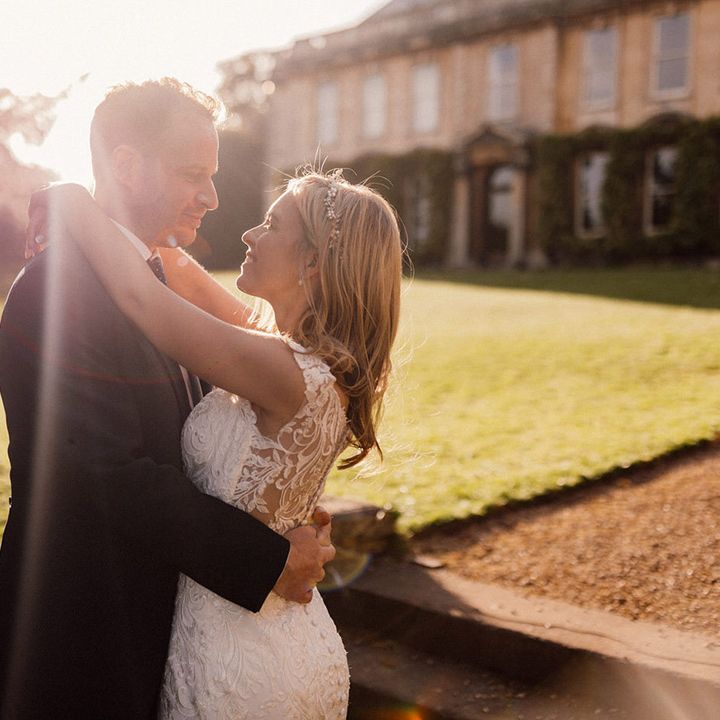 Bride and groom embrace each other during golden hour as they look into each other's eyes