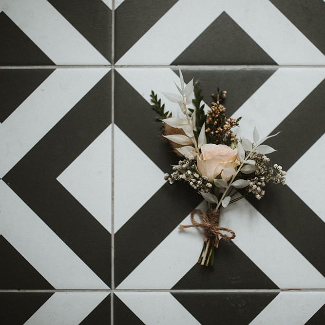 Floral buttonhole with pastel rose tied with brown string 