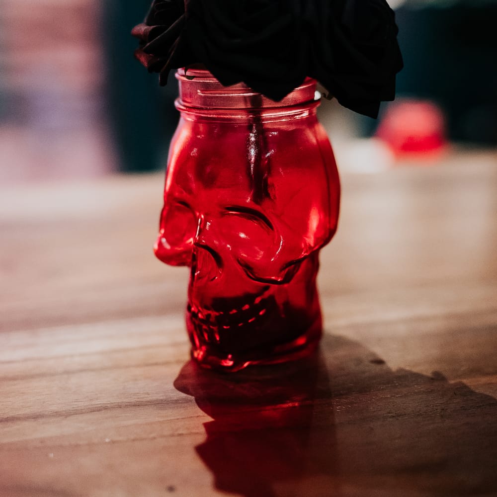 Homemade skull jars complete with black roses and feathers 