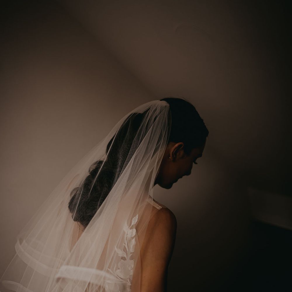 Bride wearing a layered veil walks to her wedding ceremony 