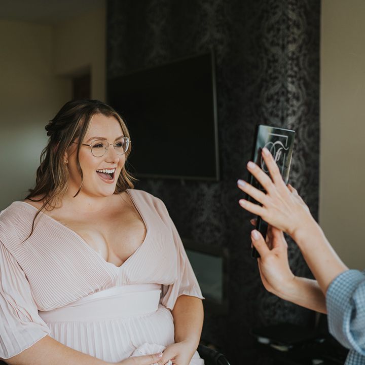 Bridesmaid wears pale pink V shaped batwing dress 