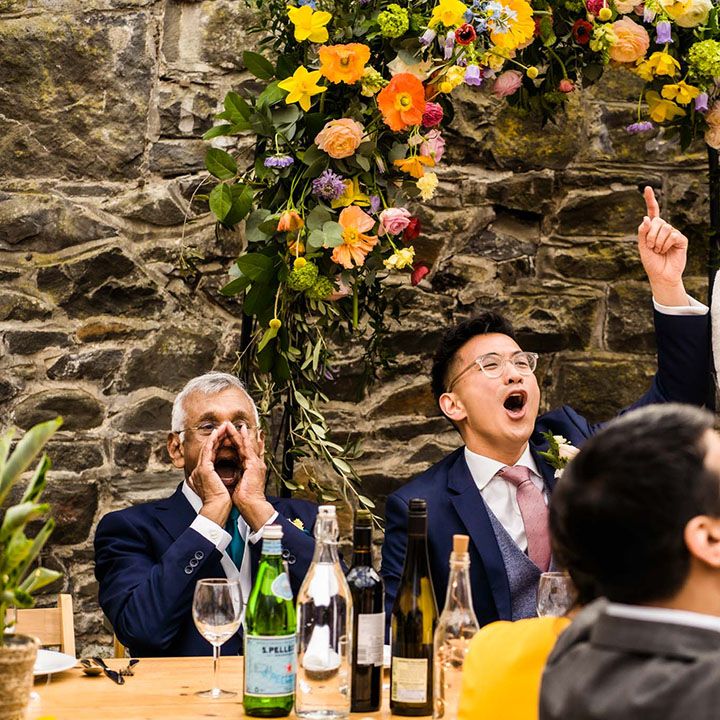 Bride gives speech during reception at Plas Dinam surrounded by colourful florals 
