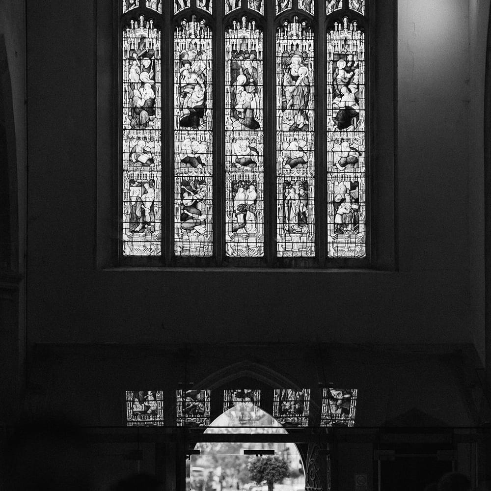 Grand church with stained glass windows with the bride walking down the aisle with the father of the bride for traditional wedding 