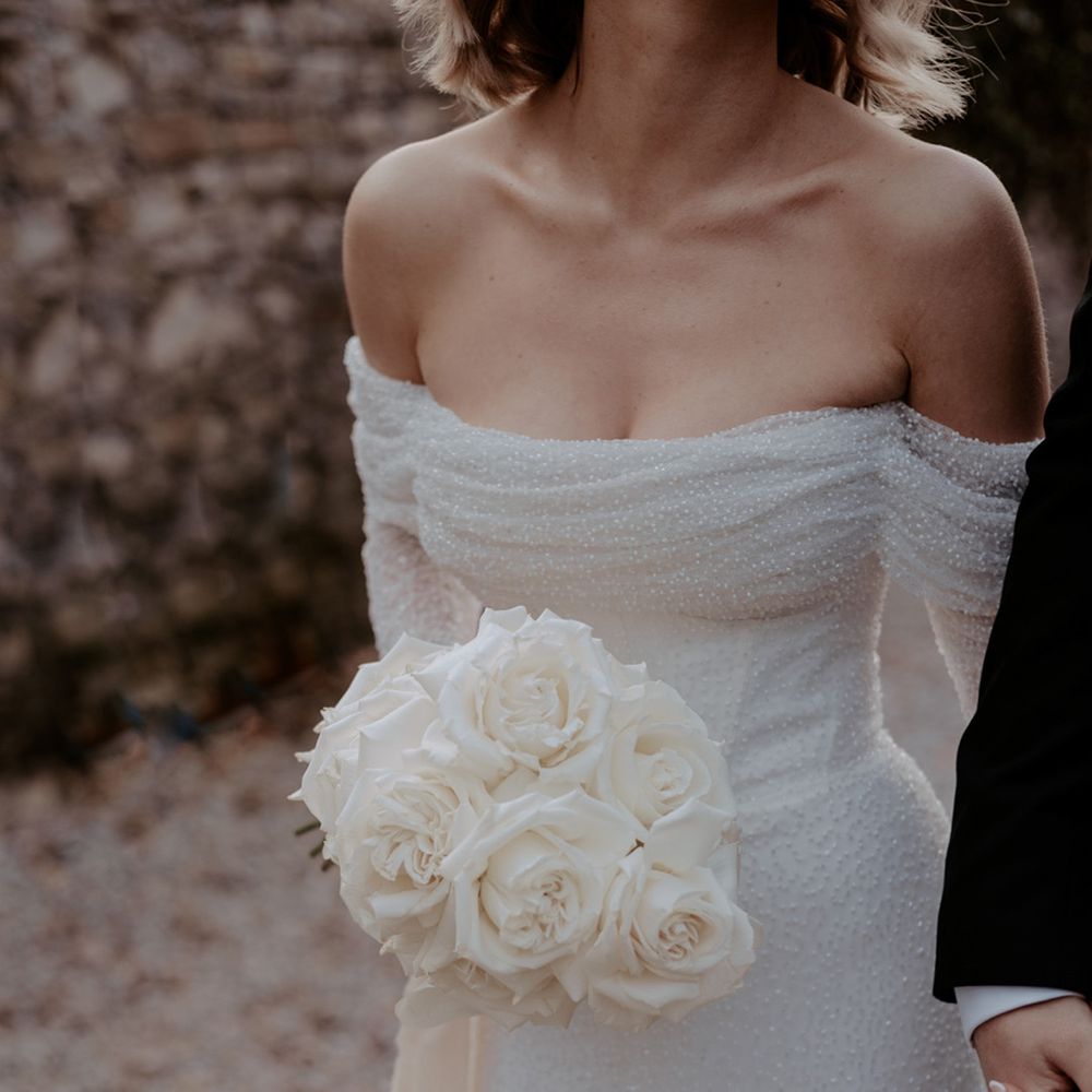 The bride holding a classic white rose wedding bouquet for the traditional wedding 