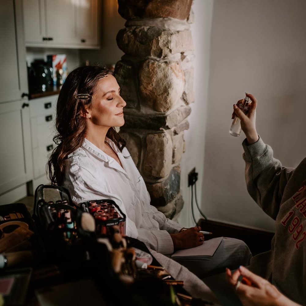 Bride in white satin bridal pyjamas doing bridal preparations photoshoot at Willow Marsh Farm Loughborough 