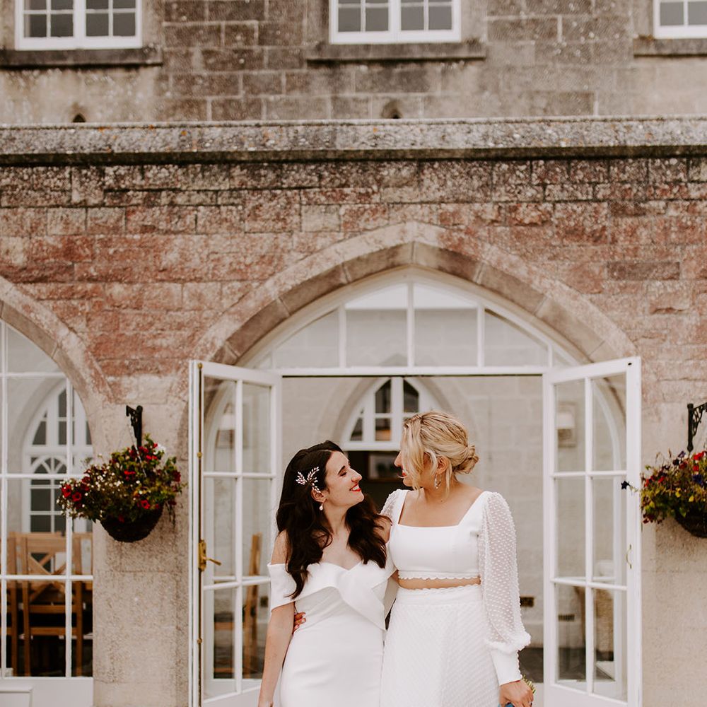 Brides carrying pastel wedding bouquet with wildflowers with one bride in an off the shoulder gown and another in bridal separates 