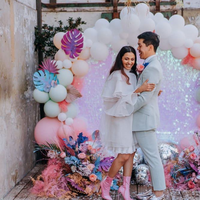 Bride and groom standing in front of a balloon installation 