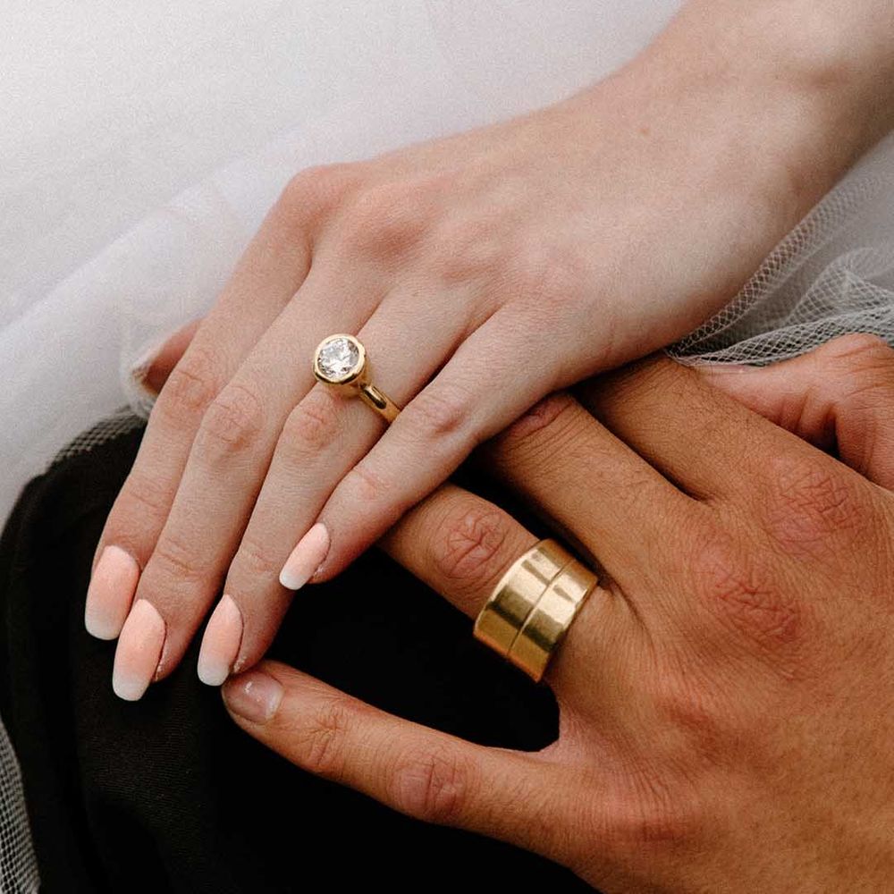 Bride and groom holding hands showing off their wedding rings