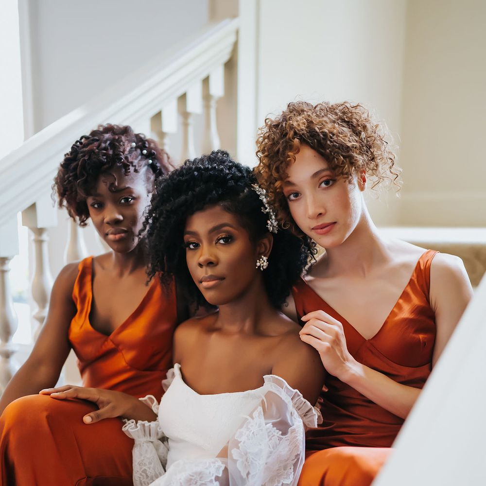 Bride and bridesmaids with natural wedding makeup and hairstyles for afro and curly haired people