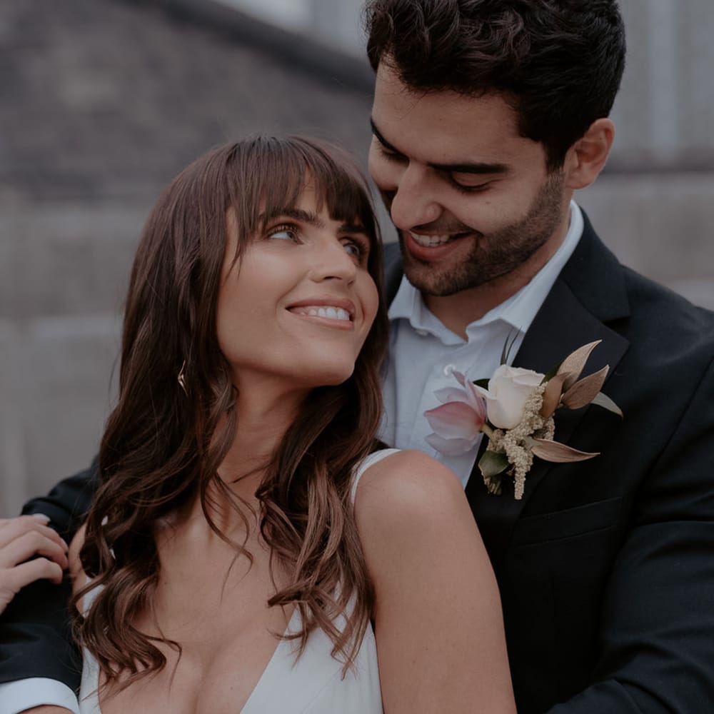 Intimate bride and groom portrait with tropical flower buttonhole and bride with bangs 