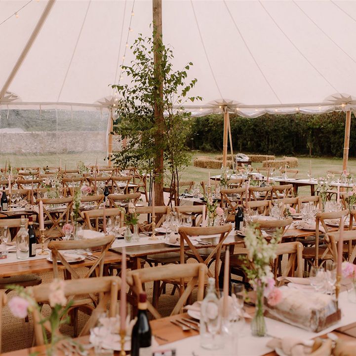 Rustic wooden tables in marquee wedding venue