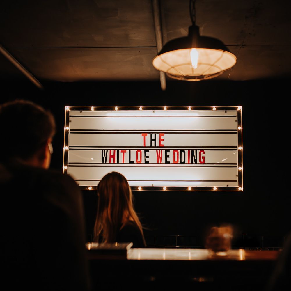 Wedding cinema style sign with red and black letters and bulb lights reading 'The Whiteloe Wedding'
