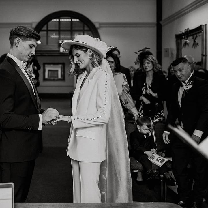 Groom puts ring on the bride during their wedding ceremony at town hall wedding 