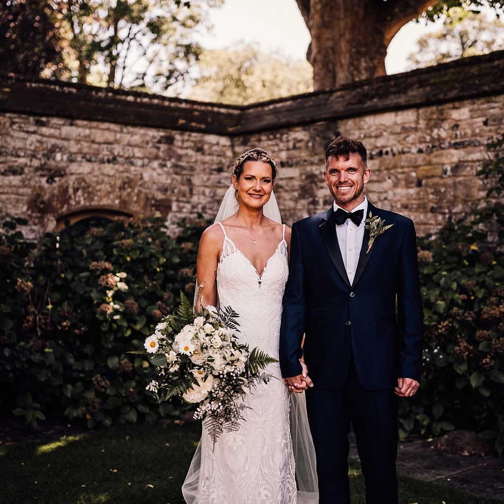 Bride and groom pose together for their couple portraits holding hands 